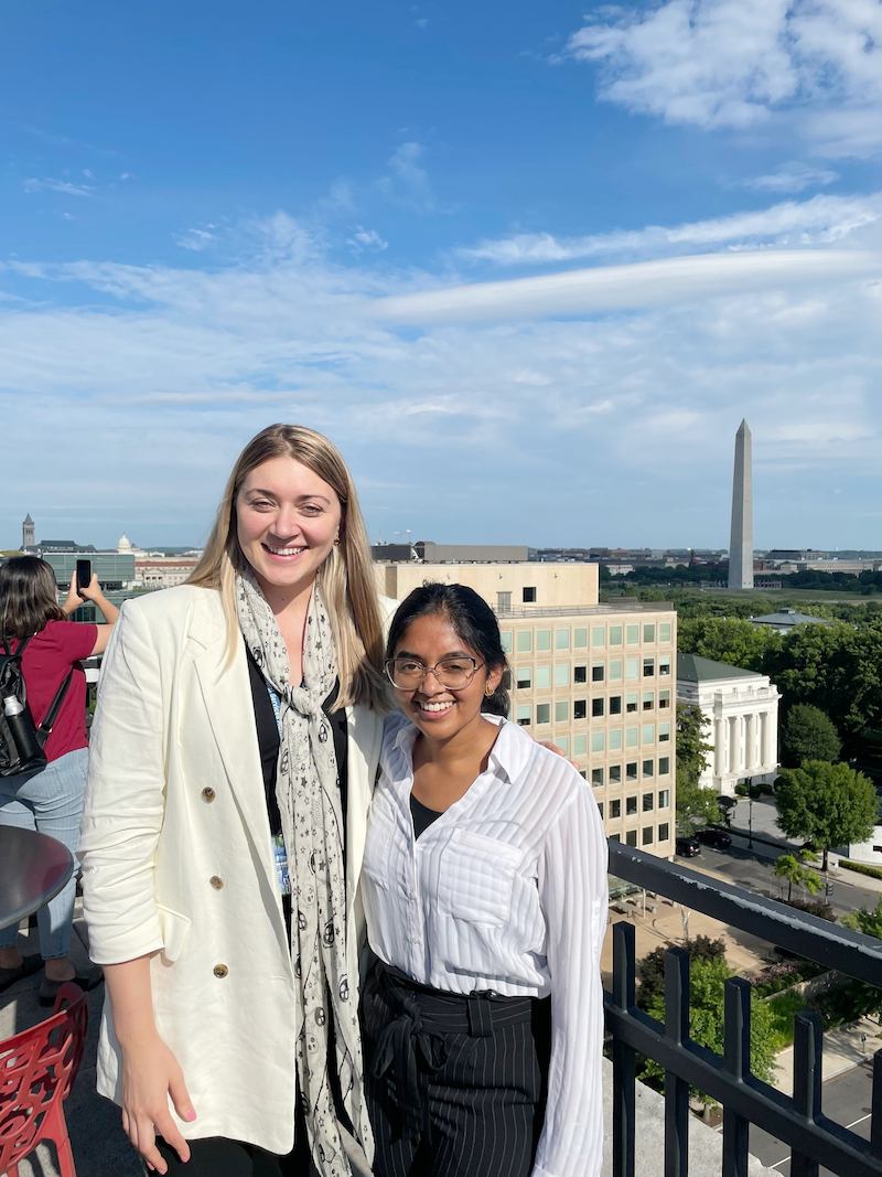 fellows standing on top of GSA rooftop wearing a burgundy hijab speaking on a video call